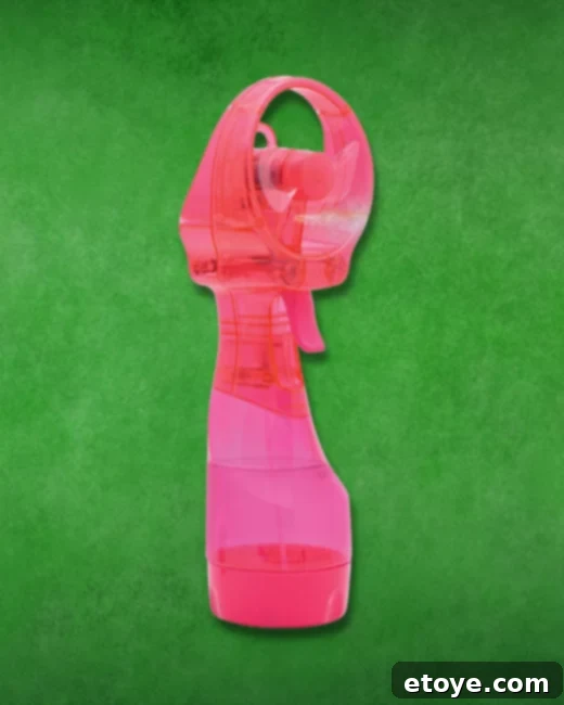 A person holding a compact, electric water bottle fan, demonstrating its portability and utility for personal cooling.