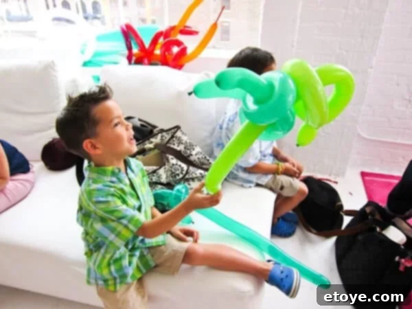 Child holding a balloon shaped like a space gun