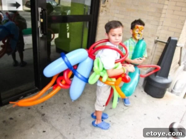 Kids with new elaborate balloon creations, one an escape ship, another a tiger