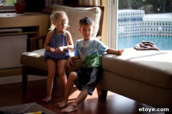 A young boy presents a colorful garland to a girl, who appears unimpressed, signaling the beginning of a childhood interaction.