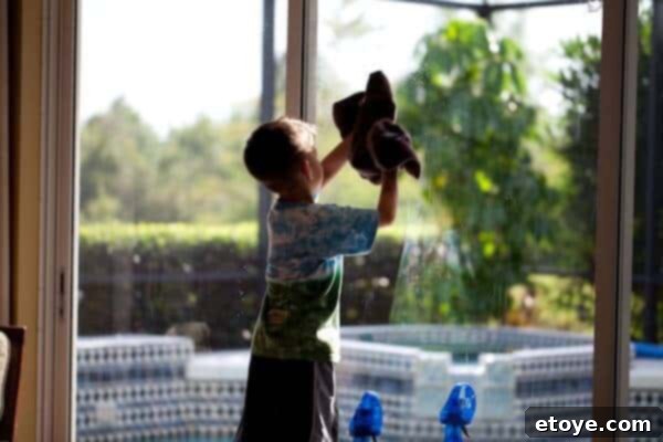A young boy diligently washes a window, demonstrating an act of service or effort during a social exchange with a girl.