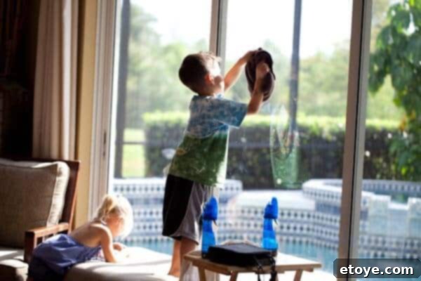With sustained effort, the boy continues washing the windows, maintaining his engagement and dedication to the shared activity.