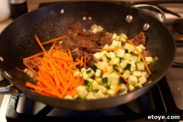 Bulgogi Rice Bowl 10 Carrots and zucchini added to the wok with beef, being stir-fried
