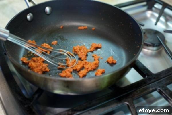 10-Minute Shrimp & Mushroom Thai Curry 5 Sautéing red curry paste in a skillet
