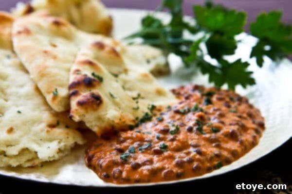 indian-dal-nirvana-recipe A bowl of creamy, rich Indian Dal Nirvana, garnished with fresh cilantro, served with a side of basmati rice or naan bread. This inviting image highlights the dish's vibrant color and luxurious texture, promising a delightful culinary experience.
