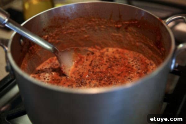 Indian Dal: Culinary Enlightenment 4 The creamy Dal Nirvana being thoroughly stirred to ensure all ingredients are perfectly combined, resulting in a consistent and smooth texture before serving.