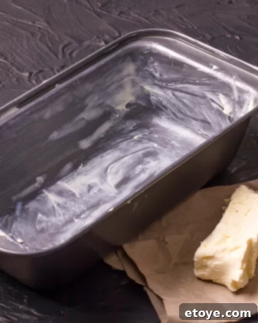 Win Instant Kitchen Upgrades 3 Hand greasing a baking sheet with a stick of butter