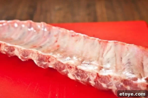 Fall-Off-The-Bone Sweet Chili Ribs 4 Baby back ribs with the membrane still attached, shown clearly before removal.