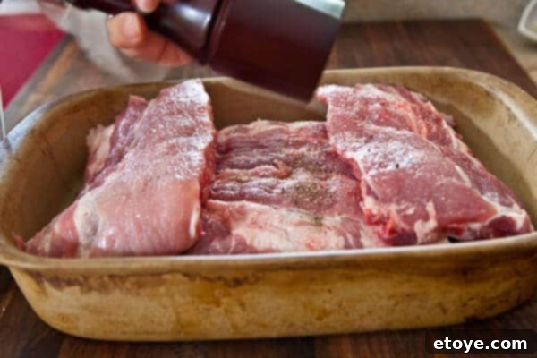 Fall-Off-The-Bone Sweet Chili Ribs 10 Baby back ribs in a pan, seasoned with pepper on both sides, ready for slow cooking to achieve fall-off-the-bone tenderness.