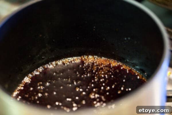 Easy homemade teriyaki sauce simmering gently in a saucepan, ready for use