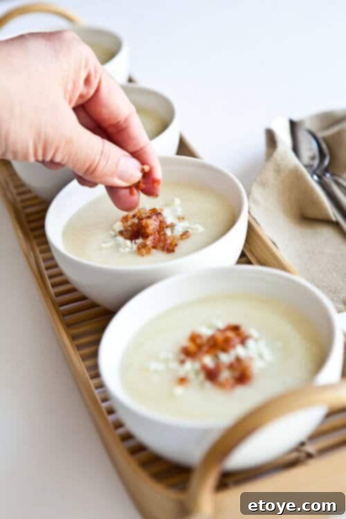 Creamy Cauliflower Soup topped with bacon and gorgonzola cheese