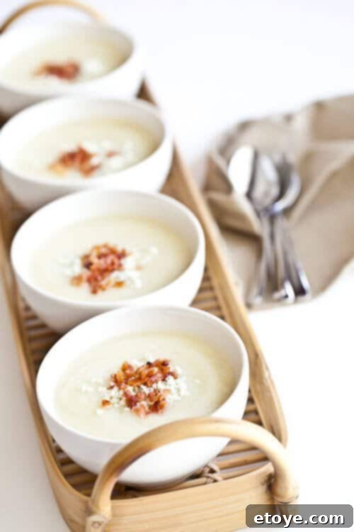 A bowl of creamy cauliflower soup with a spoon