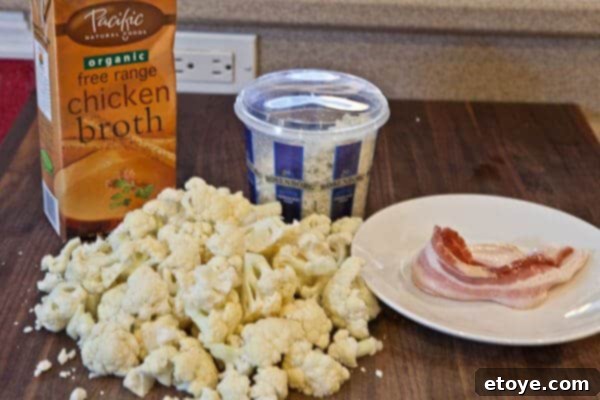 Ingredients for creamy cauliflower soup: cauliflower, broth, bacon, and gorgonzola