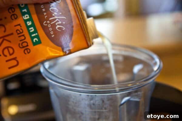 Blender with steamed cauliflower and broth, ready for blending