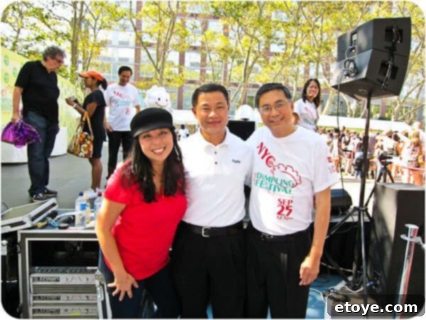 NYC Comptroller John Liu and Terry Tang, a founder of TMI Foods, engaging with another gentleman at the bustling festival