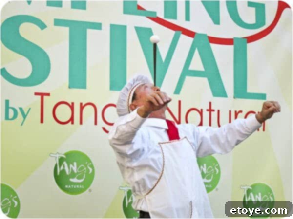 A raw egg precariously balanced atop a chopstick, which is expertly balanced on Mr. Yan Xiao Di's nose, a feat of incredible concentration