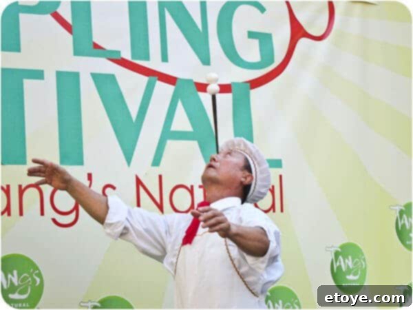 A close-up of Mr. Yan Xiao Di's face, revealing his extreme focus and control during the delicate balancing act