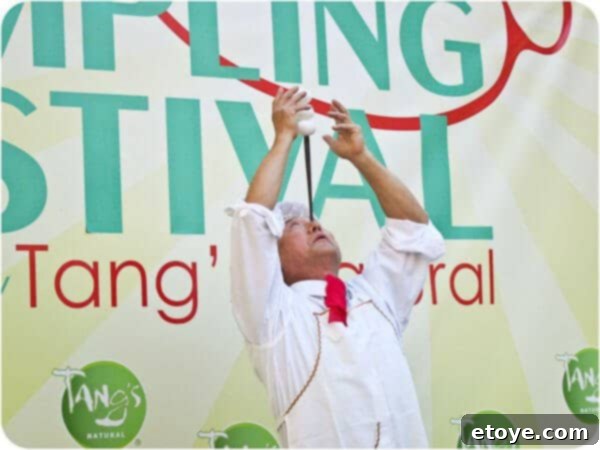 A slightly wider shot showcasing the artist's full concentration and control as he performs the impressive balance act