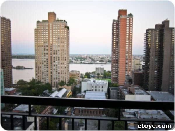 A stunning, wide-angle panoramic view of the New York City skyline from a high-rise apartment at night, adorned with countless city lights