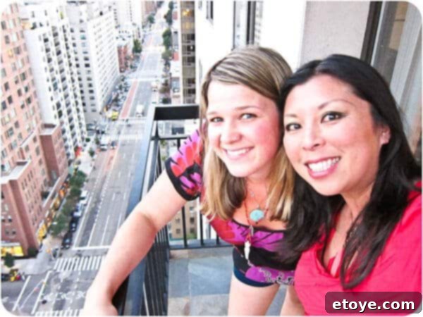 Friends enjoying the spectacular night view of the New York City skyline from a modern high-rise apartment, silhouetted against the cityscape