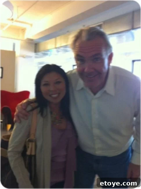 The author enthusiastically posing with the tall TV personality Gordon Elliott, sharing a charming and sweet moment over milk and cookies