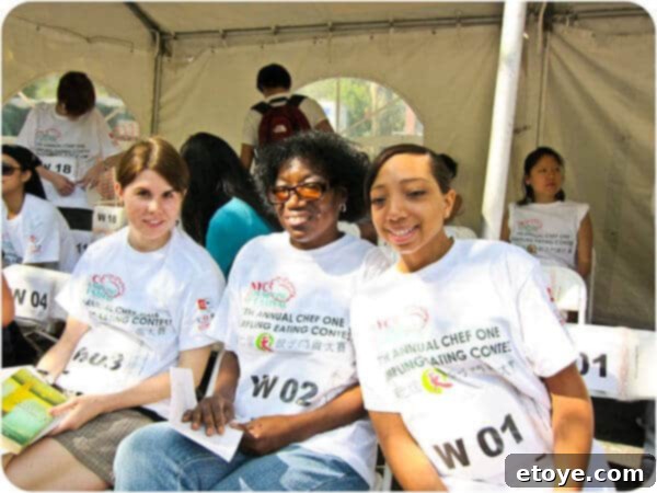 A group of slender and confident female contestants eagerly awaiting the start of the dumpling eating contest