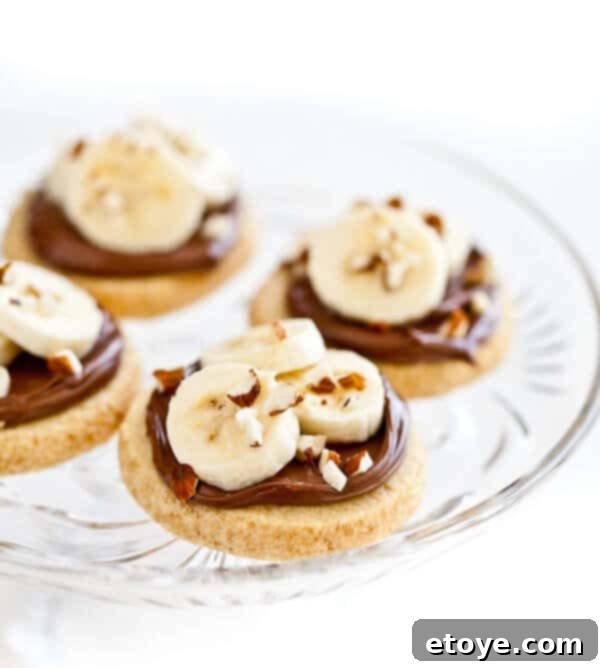 shortbread-cookies-nutella-banana-almonds-4678 Delicious shortbread cookies topped with smooth Nutella, fresh banana slices, and crunchy almonds.