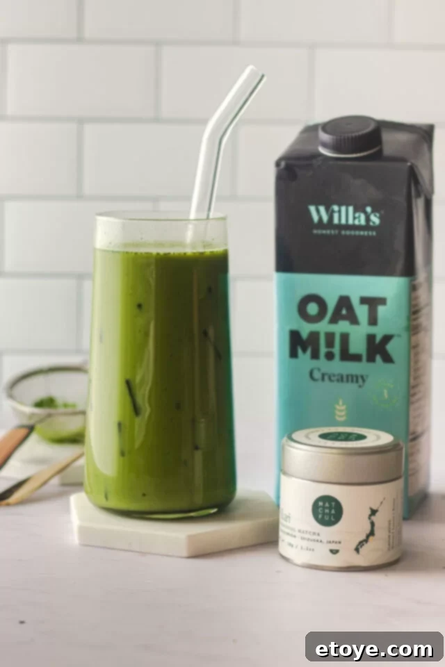 Glass of iced matcha latte with oat milk.