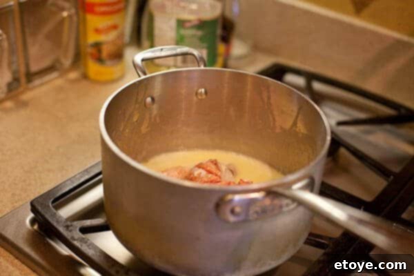 butter poached lobster cooking in pot