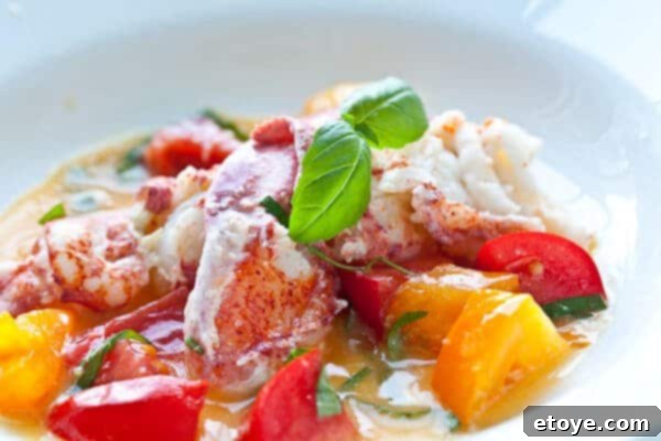 close up of butter poached lobster with fresh tomatoes and basil