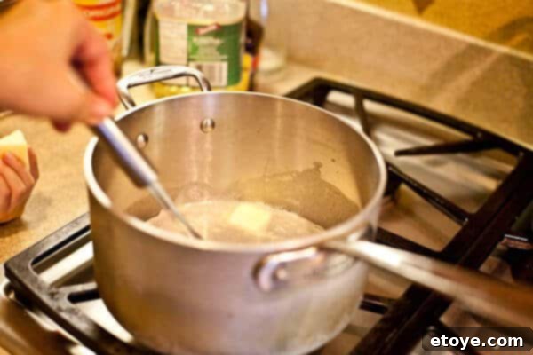 whisking butter into creamy sauce