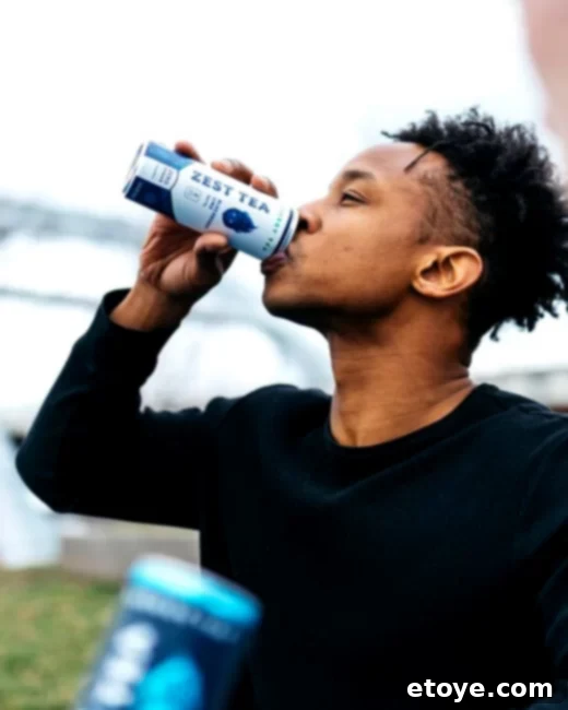 Person pouring Zest Tea from a can into a glass