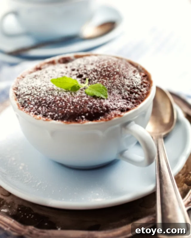 Heavenly Nutella Chocolate Cake 5 Close-up shot of a rich and moist chocolate Nutella cake in a blue mug, highlighting its inviting texture.