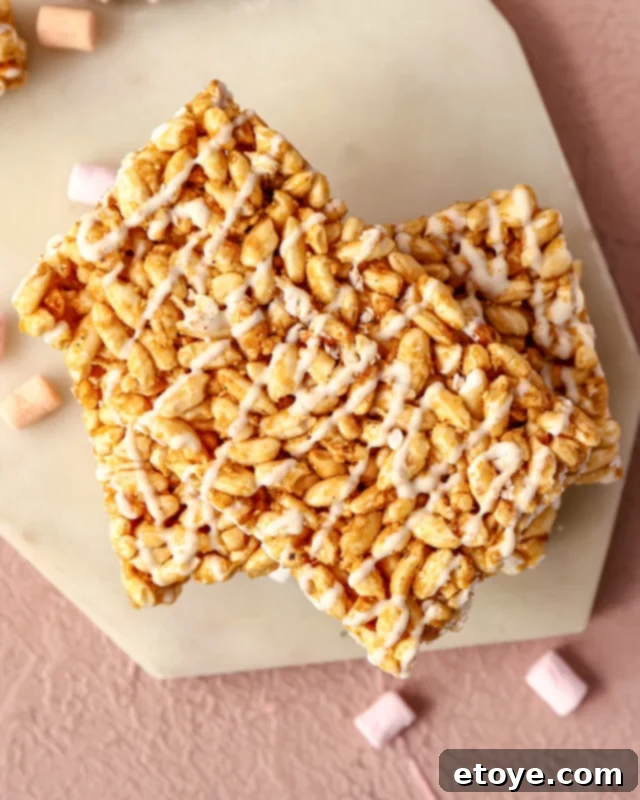 Rice Krispie treats generously drizzled with white chocolate, looking elegant and delicious.