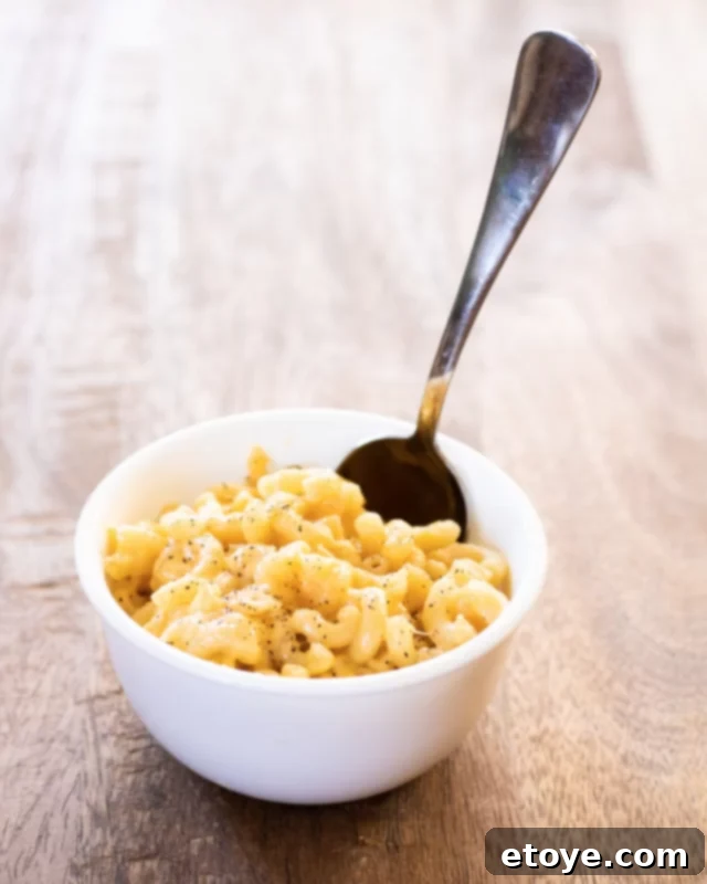 A perfectly portioned bowl of creamy microwave mac and cheese, sprinkled with black pepper, ready to be enjoyed.