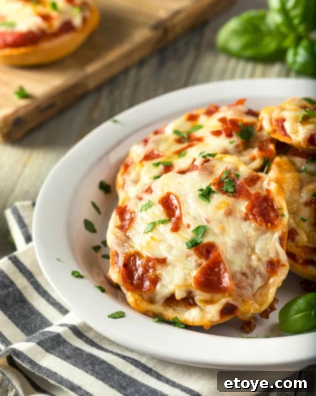 Cheesy pizza bagel bites with fresh herbs, ready to eat.