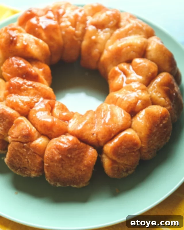 Monkey bread with butter and cinnamon sugar over the top on a green plate. 