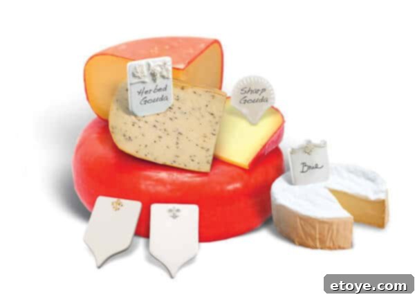 Win Cheese Tiles 3 A close-up of a cheese board showing a variety of cheeses, fruits, and nuts, with elegant ceramic cheese tiles labeling each cheese.