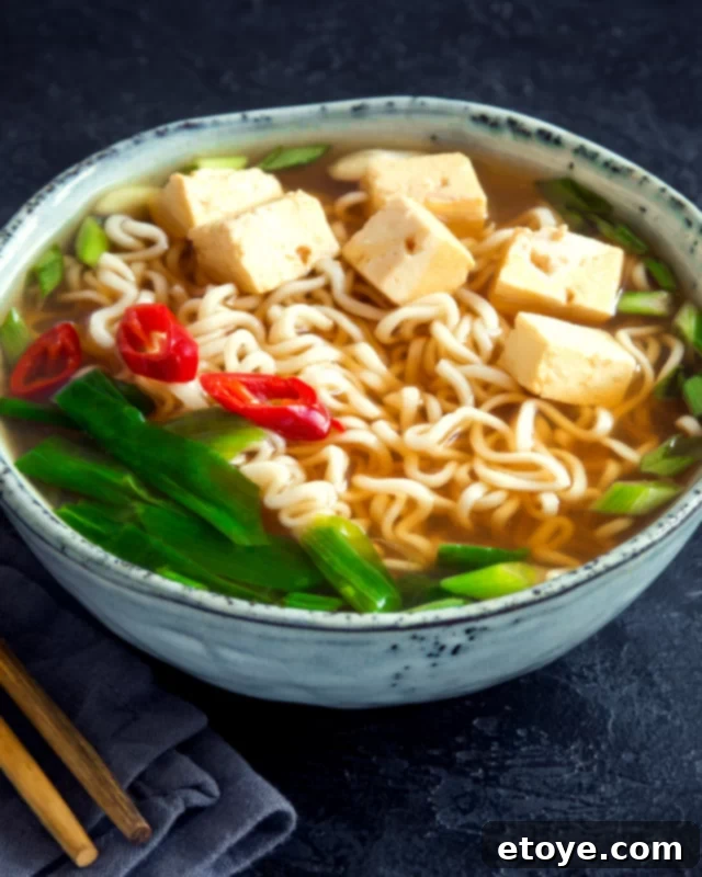 Elevate Your Microwave Ramen 4 A beautifully arranged bowl of microwave ramen, featuring golden noodles, tender tofu cubes, vibrant green spinach, and a perfectly cooked egg, ready for a delicious meal.