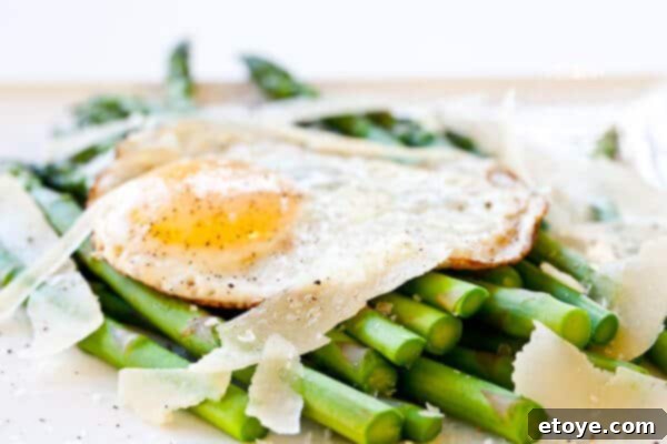 Asparagus with Fried Egg and Parmesan Cheese Recipe Asparagus spears with a sunny-side up fried egg and shaved Parmesan cheese