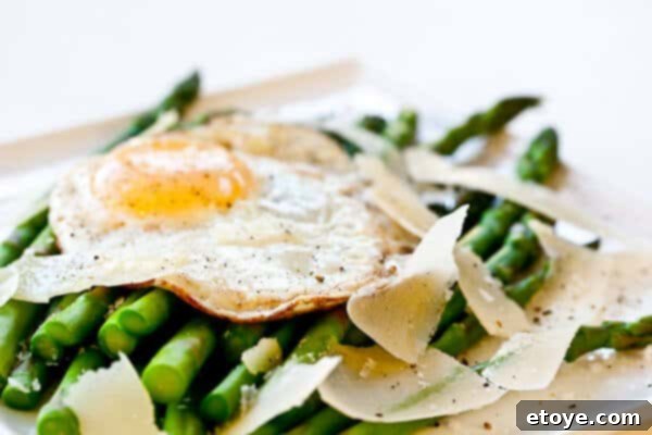 Asparagus with Fried Egg and Parmesan Cheese Recipe Golden, runny yolk spilling over asparagus and cheese