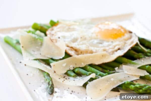 Asparagus with Fried Egg and Parmesan Cheese Recipe Freshly shaved Parmesan cheese on a cutting board