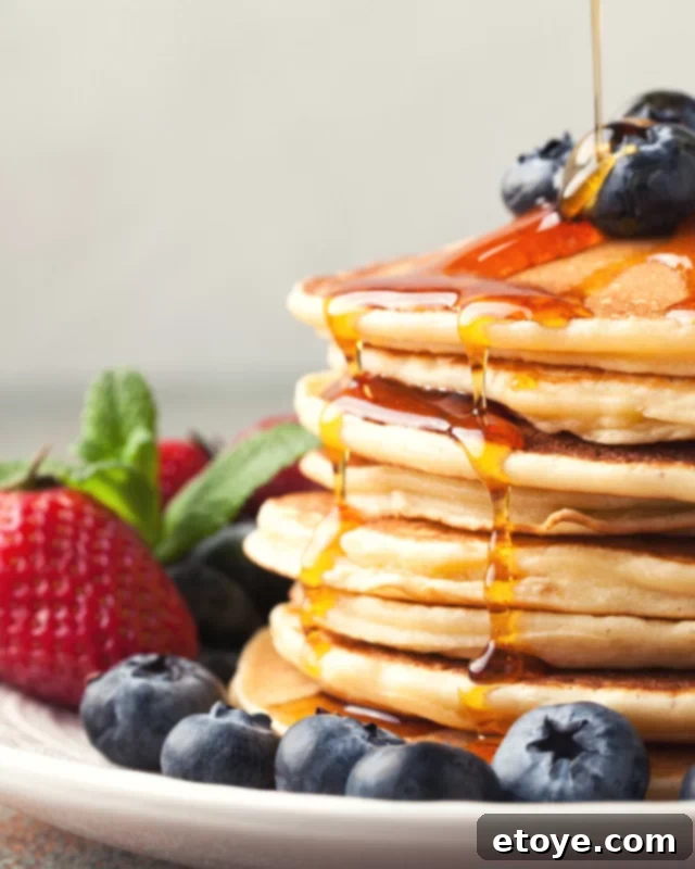 Microwave Pancakes: Quick and Easy Delights 2 Stacked fluffy microwave pancakes dripping with maple syrup, ready to eat.