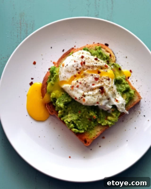 Easy Microwave Poached Eggs 4 A perfectly poached egg resting on a slice of avocado toast, garnished with a sprinkle of seasoning, showcasing an ideal breakfast or brunch option.