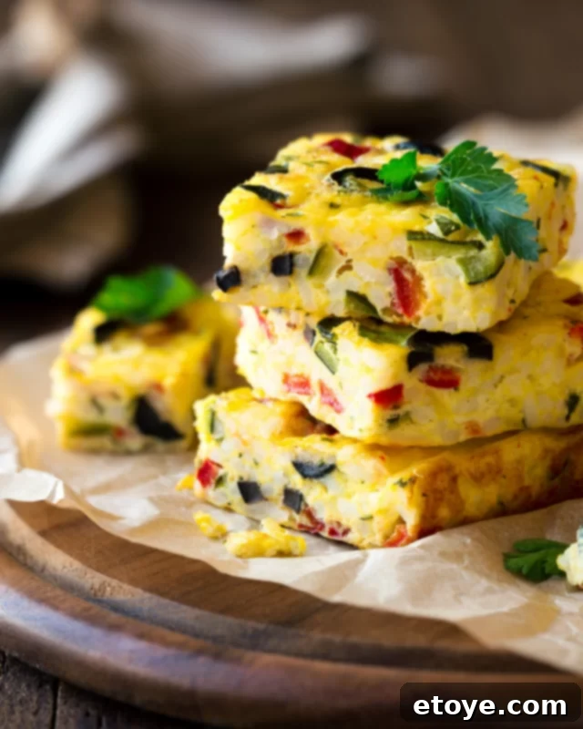 Effortless Microwave Frittata 2 Golden vegetable frittata slices stacked on parchment paper, showcasing a fluffy texture and vibrant ingredients, ready for a quick breakfast or brunch.