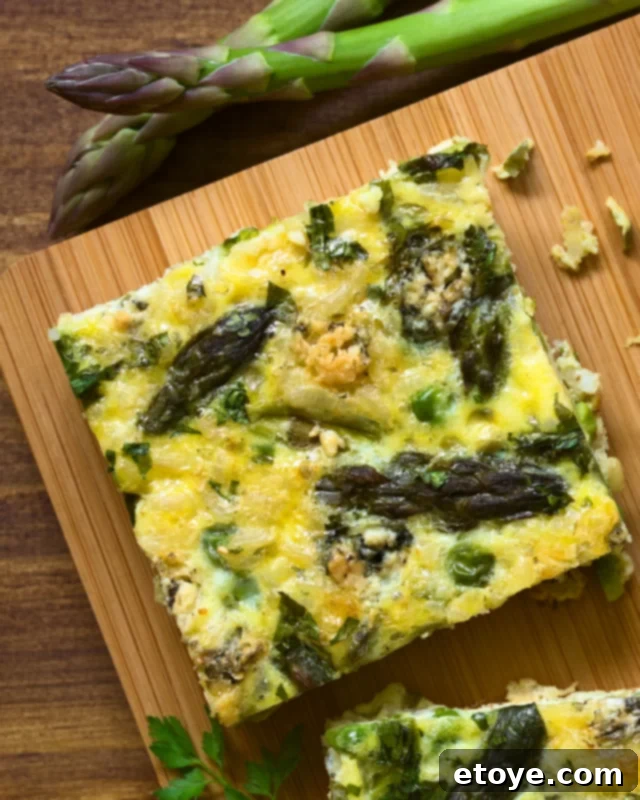 Effortless Microwave Frittata 4 A single, perfectly cooked slice of asparagus frittata, showcasing a fluffy texture and vibrant green asparagus pieces, ready to be enjoyed.