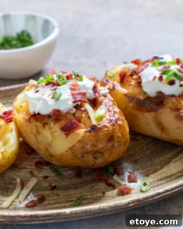 Microwave Baked Potato Perfection 4 A baked potato topped with sour cream and crispy bacon bits, ready to eat.