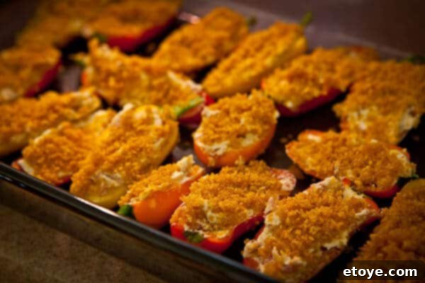 Crispy Baked Jalapeno Bacon Poppers 12 Baked sweet mini pepper poppers, golden brown and crispy, served hot on a tray.
