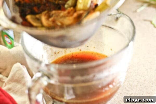 Smooth, rich red wine jus poured into a serving jug.