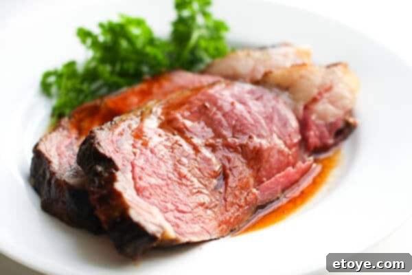Perfectly carved prime rib slices served on a platter, accompanied by a rich jus.